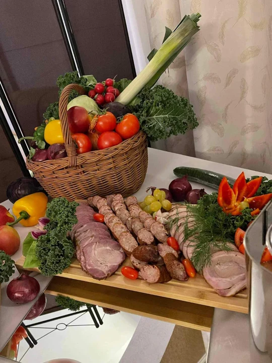 Wędliny i kosz warzyw na rustykalnym bufecie