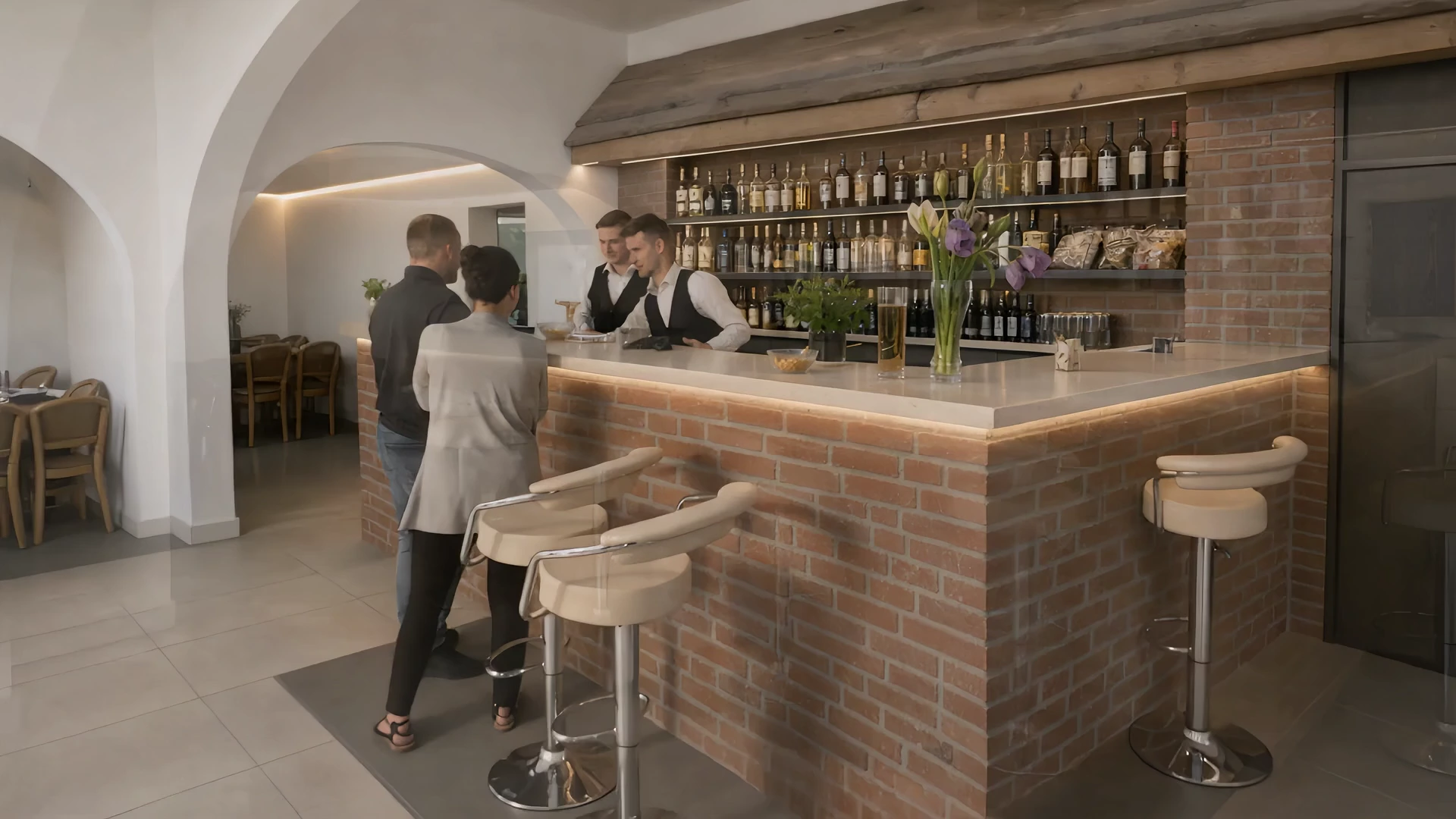 Bar z jasnym blatem i ceglanym frontem pod sklepionymi łukami